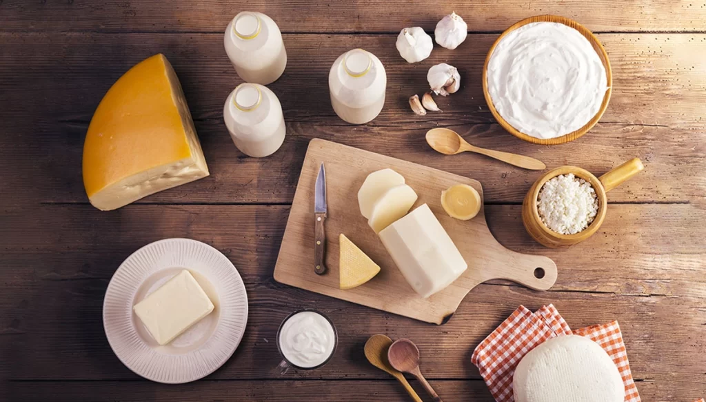 a variety of different cheeses on a wooden table