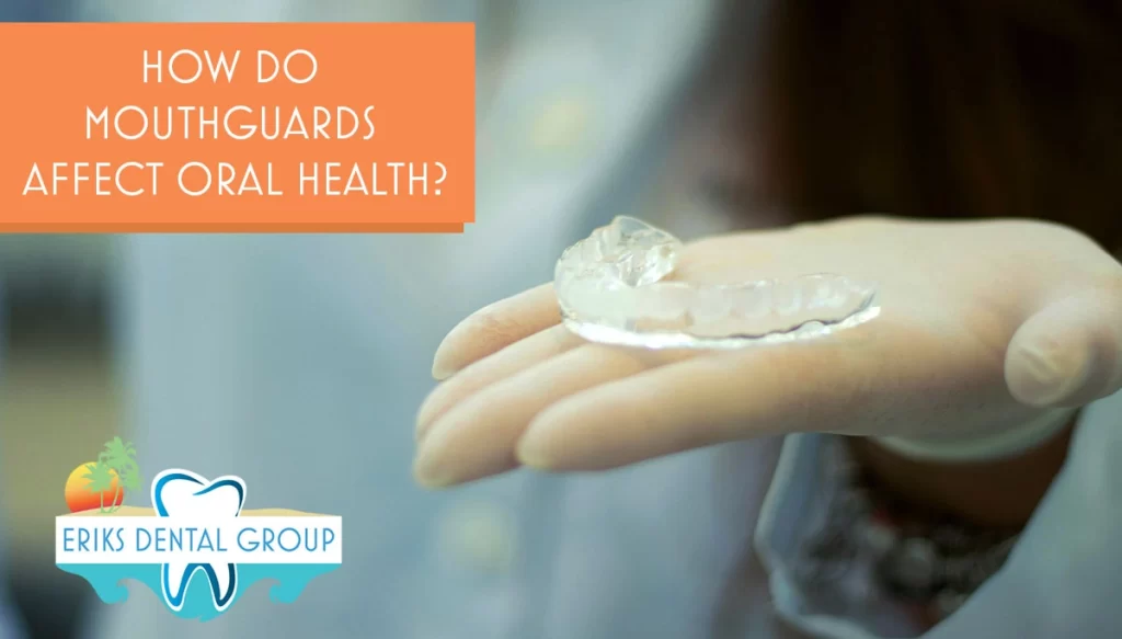 A gloved hand holding mouth guard