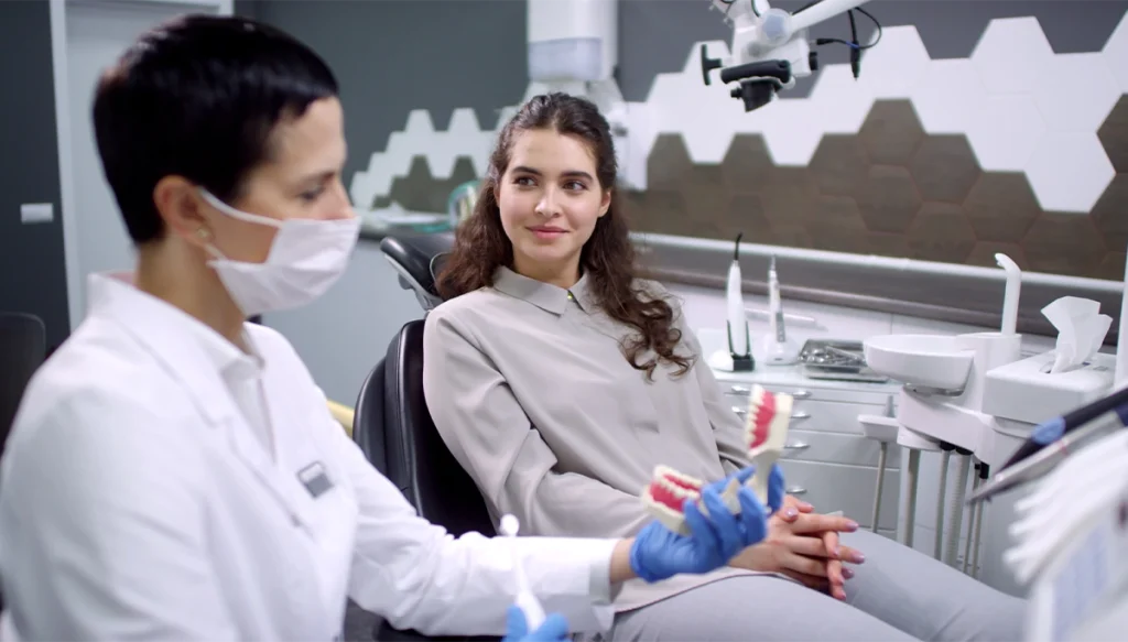 dentist showing patient a model of dentures
