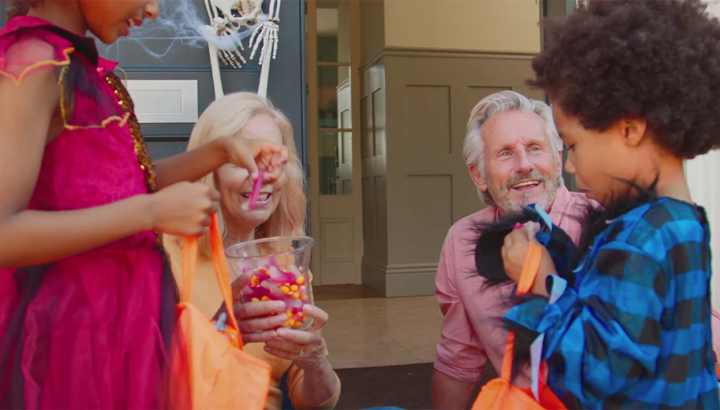 Older couple giving candy to two young children