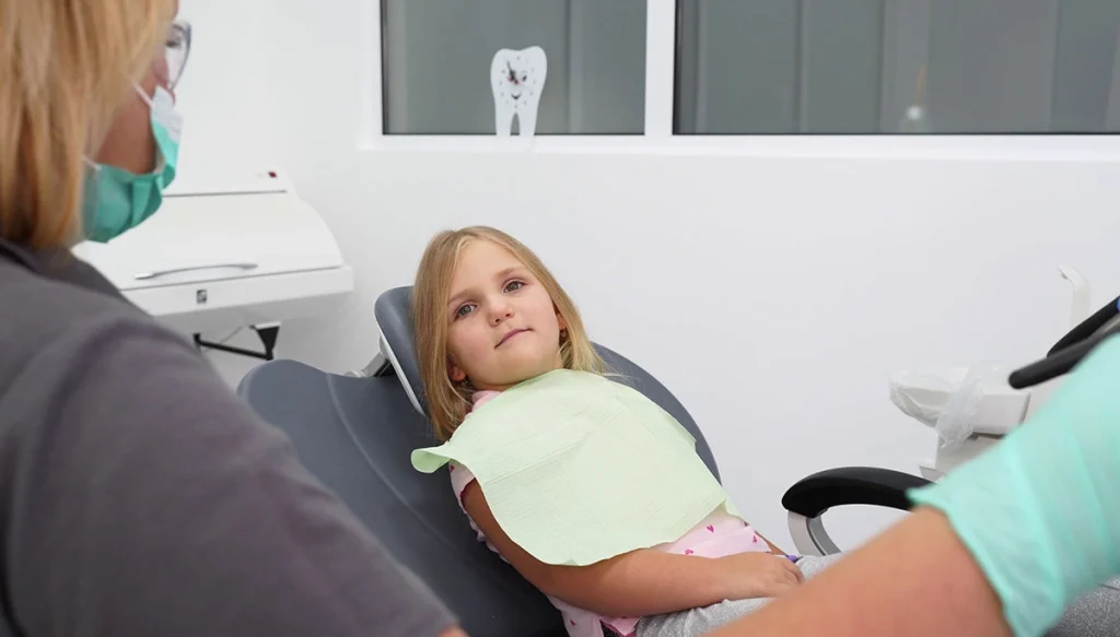 young girl sitting in dentist chair