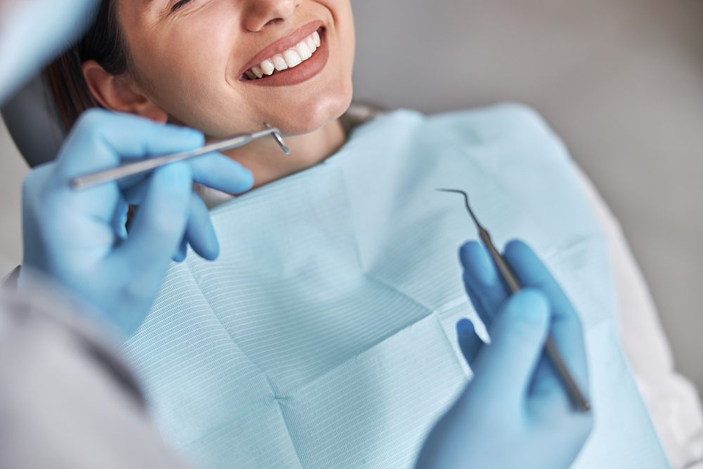 woman smiling in dentist chair with dental tools in the foreground